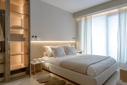 Dormitorio moderno con vestidor y estanterías iluminadas — proyecto Diwan , por Diwan Interiorismo, en Belgrano